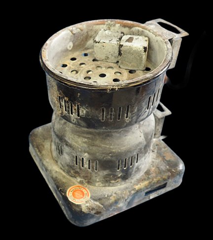 A typical electric coil burner, heavily corroded and ash-covered after less than a year of regular use.